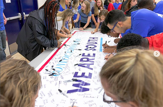 Students signing a banner at Convocation