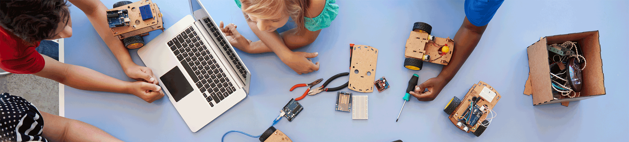 Kids working on computer and car.