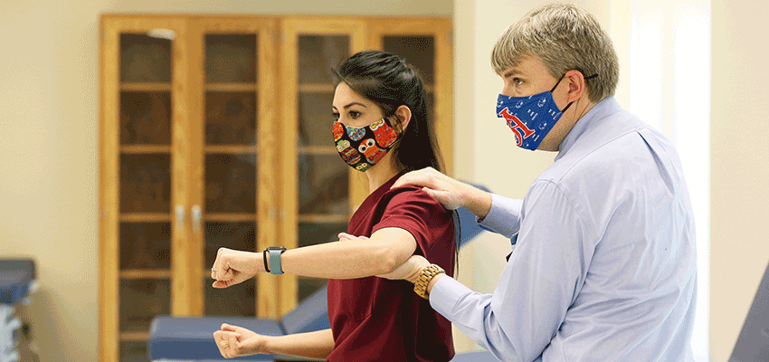 Image of Physician Assistant Studies instructor in lab with student.