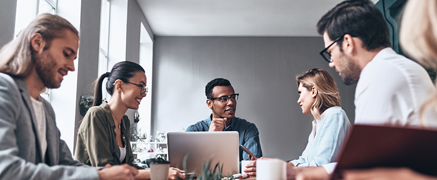 Graduate students working at a table talking.