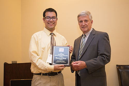 Dr. Bill Williams presents an Endowment Scholarship to Cameron Young.