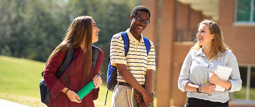 Two female students and one male student outside the Chemistry building