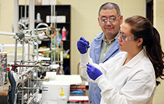 Student working in chemistry lab with professor