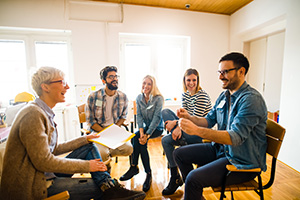 A group of people sitting in a circle talking.