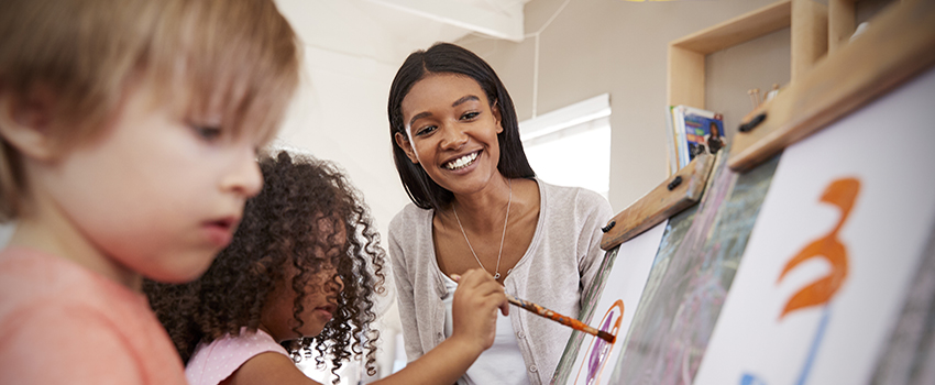 Teacher working with students painting.