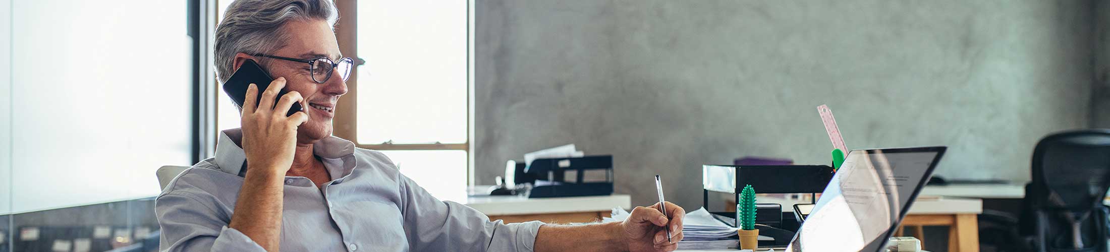 Man talking on phone working at desk.