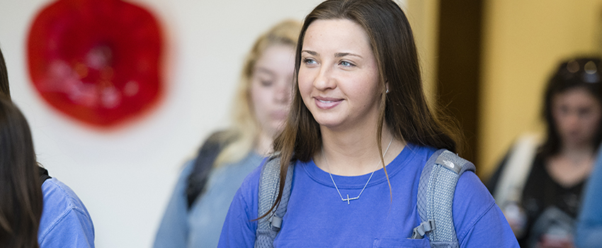 Female student with backpack on smiling