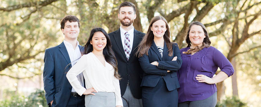 What is Management Featured Image showing Management students outside in front of trees.