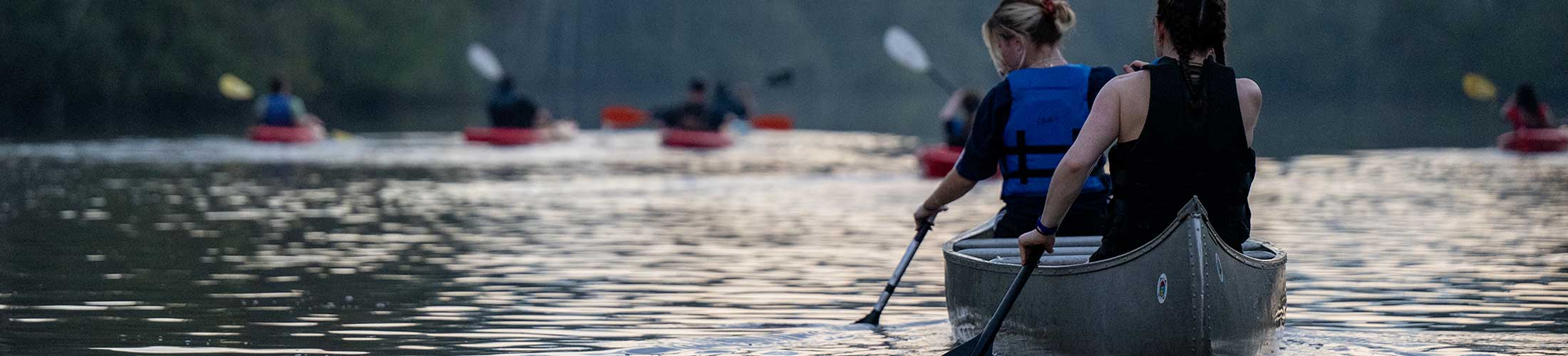 Student on a moon light paddle in a canoe