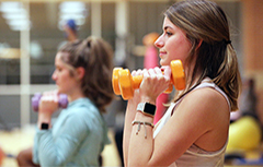 Female student lifting dumbbells