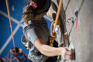 Student climbing on rock wall.