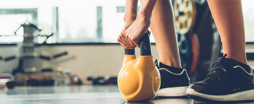 Person lifting kettle bell.