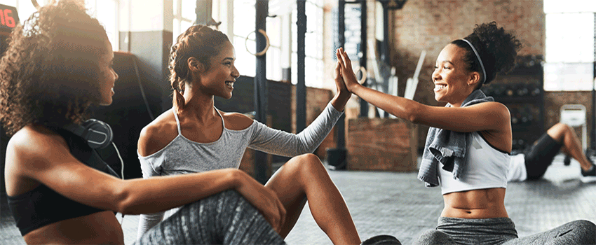 People high fiving after a workout in a gym.