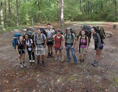 Group picture outside with people wearing backpacks