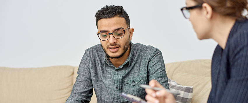 Man talking to woman in counseling session.