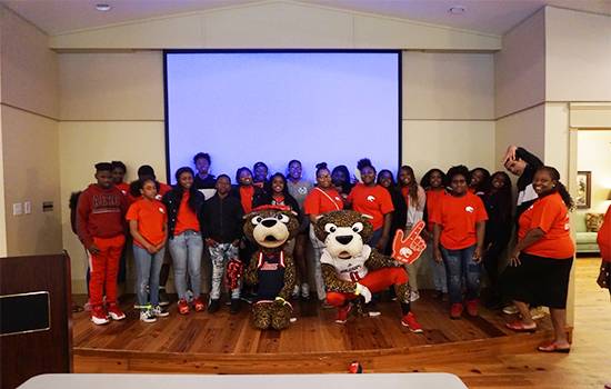 Group shot with Southpaw and Ms Pawla in front of a screen in class.