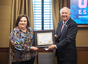 Jan Wilson holding plaque with President Jo Bonner.