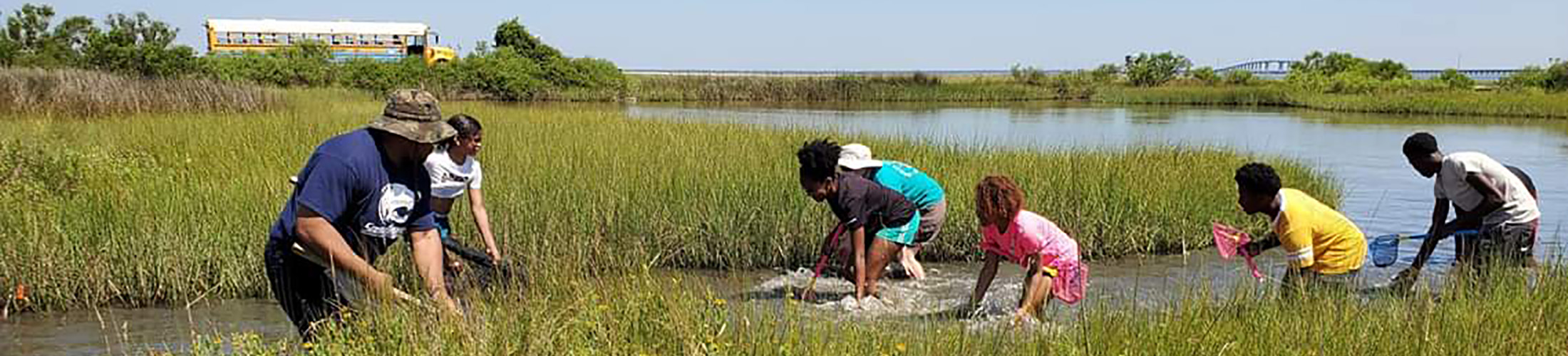 Upward Bound students in the water collecting trash.