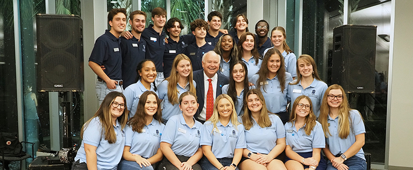 Students sitting on stage with President Bonner.