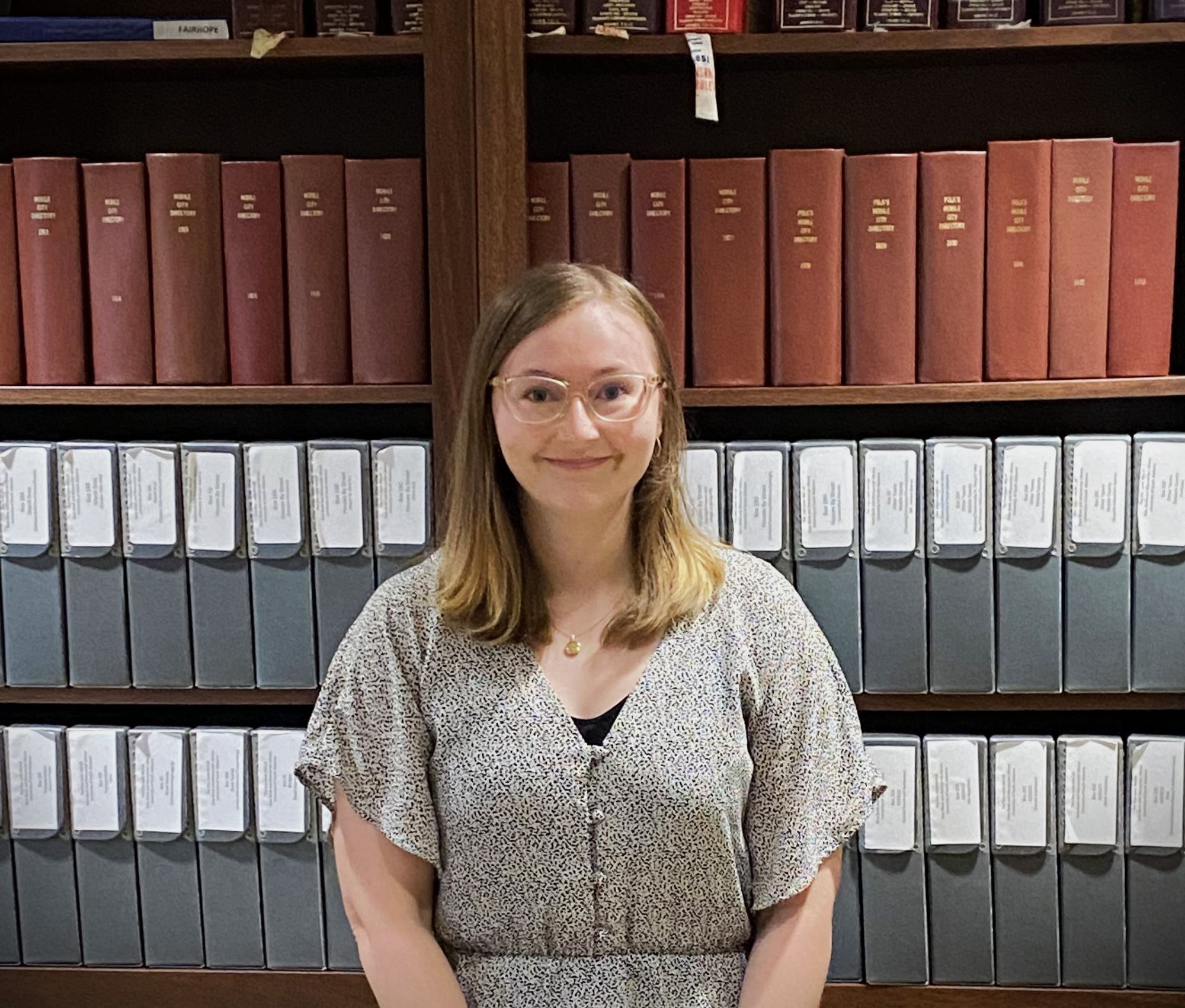 Santana Harmon is pictured standing in front of the book cases in the McCall reading room.