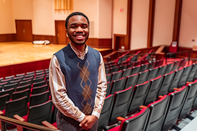 Student smiling in between rows of theatre.